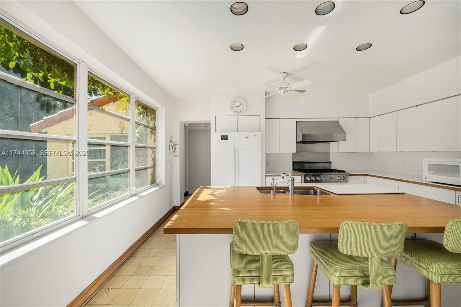 4197 Douglas Road Miami, FL 33133 - Photo 13 of 42 a kitchen with a table chairs microwave and cabinets