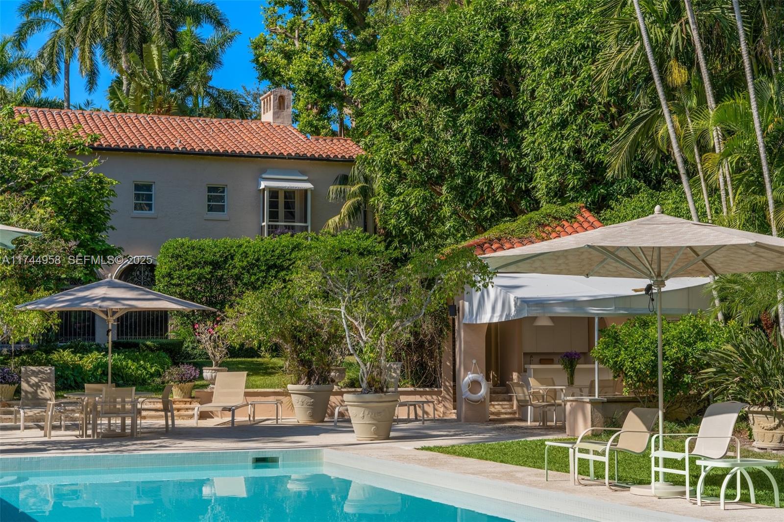 4197 Douglas Road Miami, FL 33133 - Photo 25 of 42 a patio with a table and chairs under an umbrella