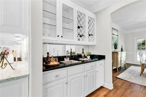 a kitchen with a dining table chairs and white cabinets