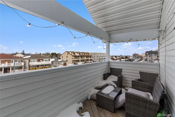 a view of a balcony with couches and wooden floor