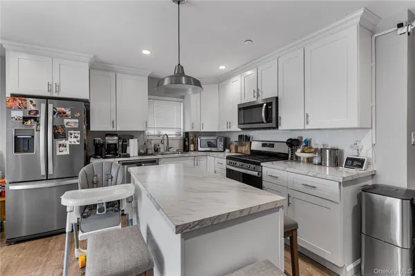 a kitchen with kitchen island granite countertop stainless steel appliances stove microwave and cabinets