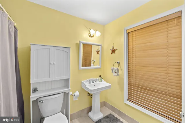 a view of a bathroom with shower curtain