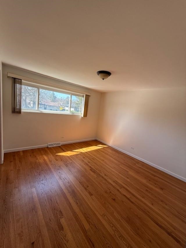 939 South Grace Street Lombard, IL 60148 - Photo 13 of 26 a view of an empty room with wooden floor and a window
