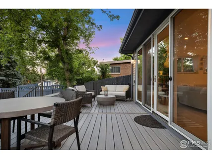 a balcony with wooden floor table and chairs