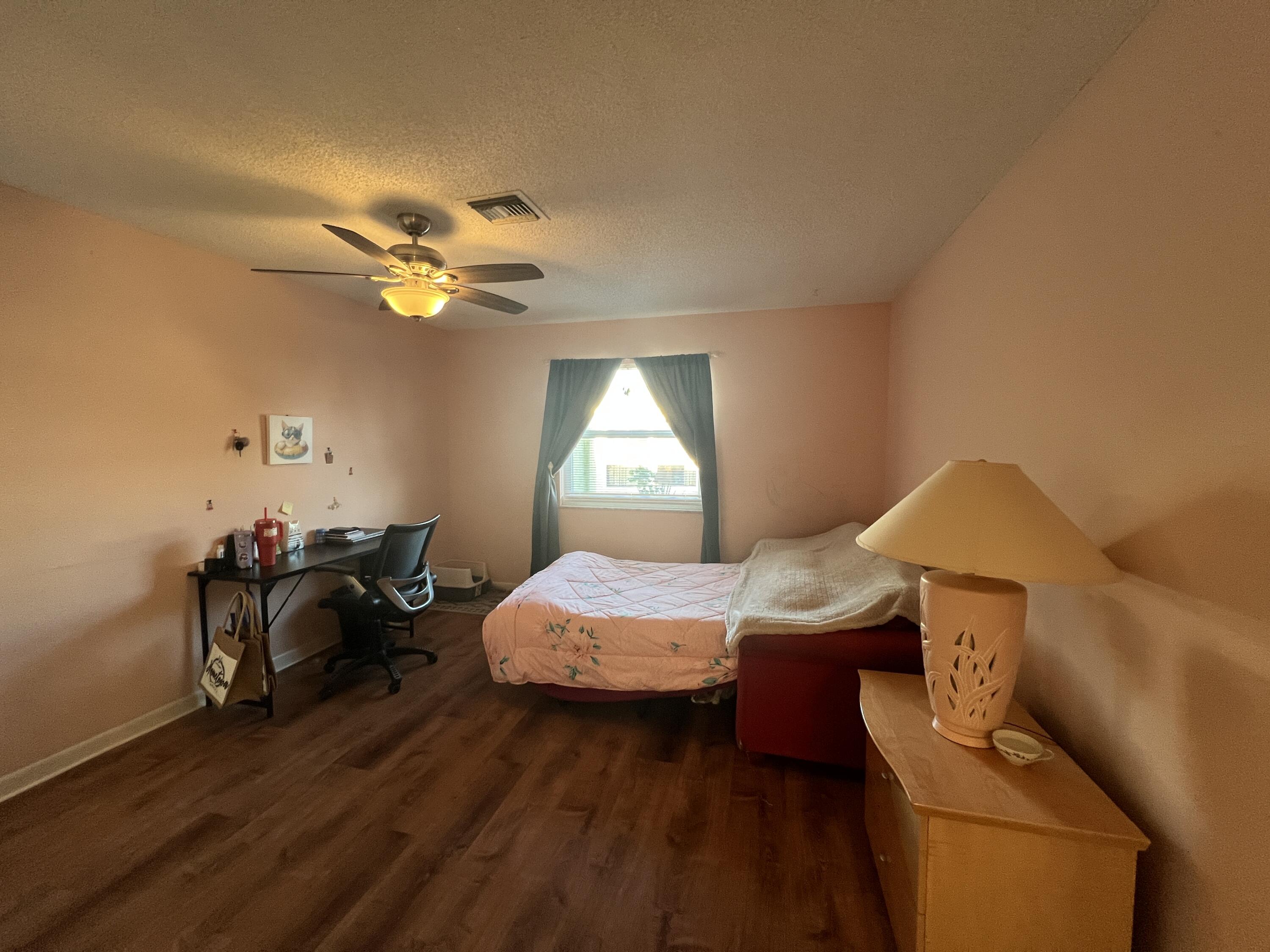 1150 Boxwood Drive, Unit 202 Delray Beach, FL 33445 - Photo 13 of 19 a bedroom with a bed and a chandelier