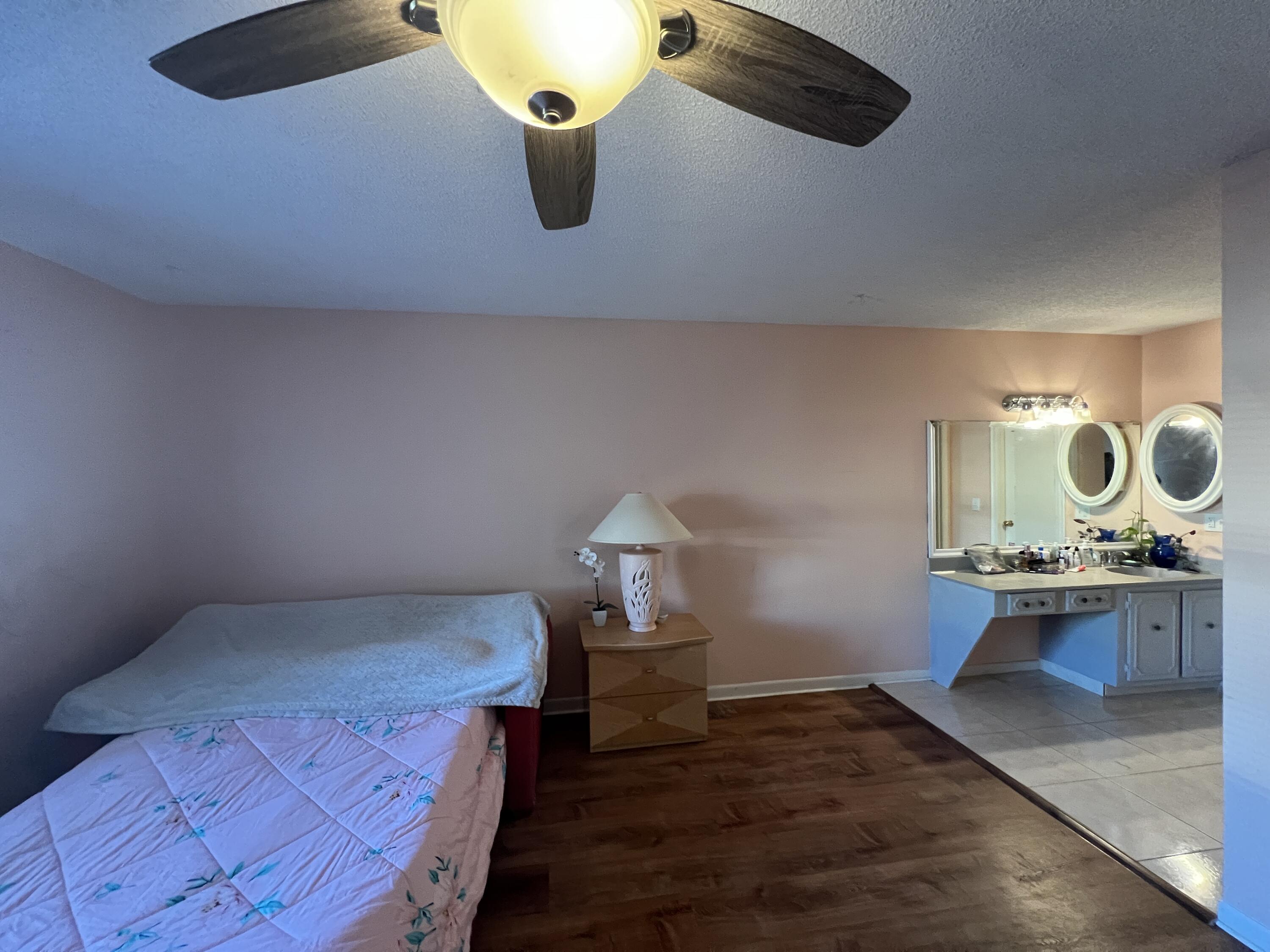 1150 Boxwood Drive, Unit 202 Delray Beach, FL 33445 - Photo 14 of 19 a bed room with furniture and mirror