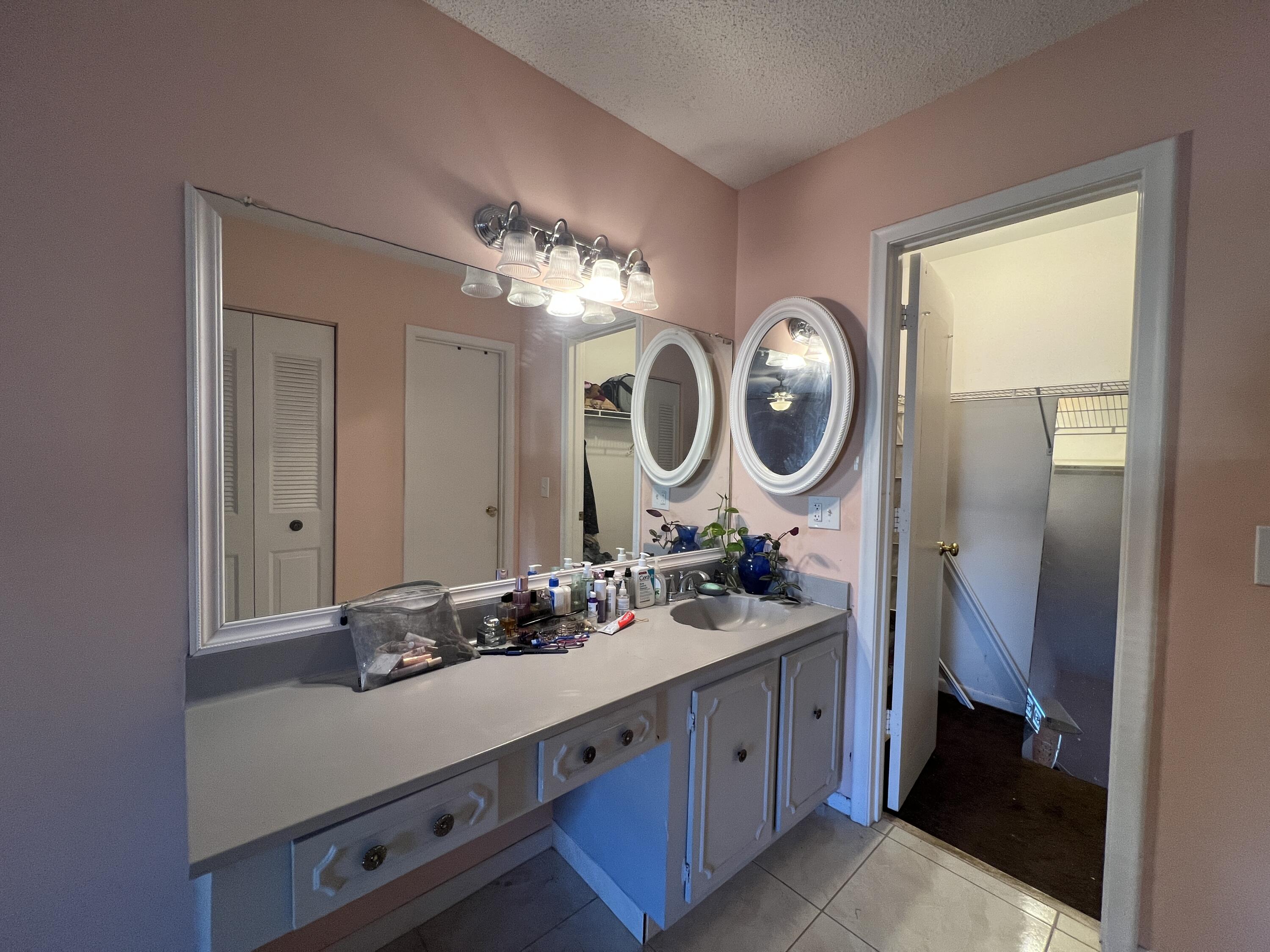 1150 Boxwood Drive, Unit 202 Delray Beach, FL 33445 - Photo 15 of 19 a bathroom with a double vanity sink and a mirror