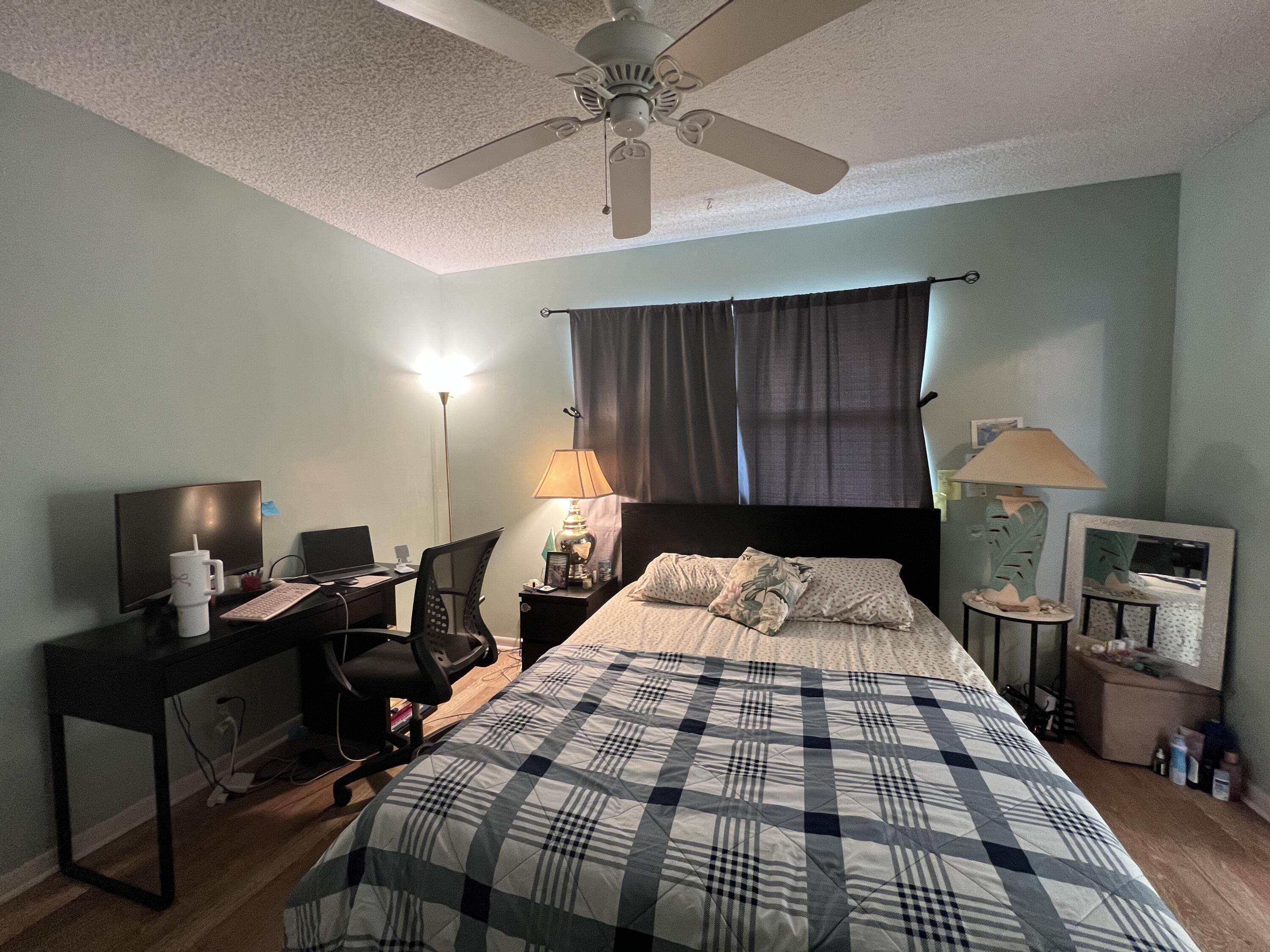 1150 Boxwood Drive, Unit 202 Delray Beach, FL 33445 - Photo 17 of 19 a bedroom with a bed and a table in it