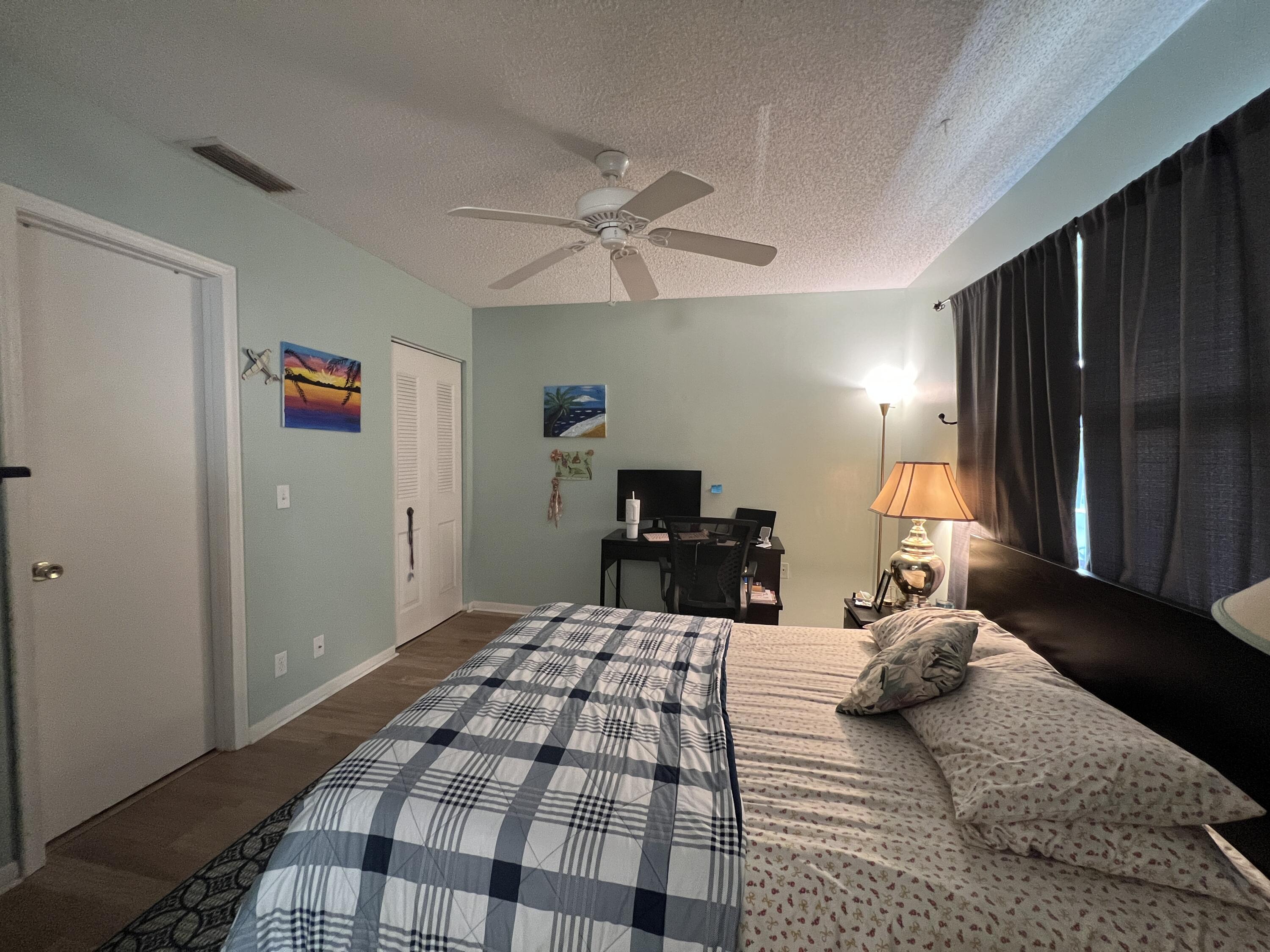 1150 Boxwood Drive, Unit 202 Delray Beach, FL 33445 - Photo 18 of 19 a bedroom with a bed and wooden floor