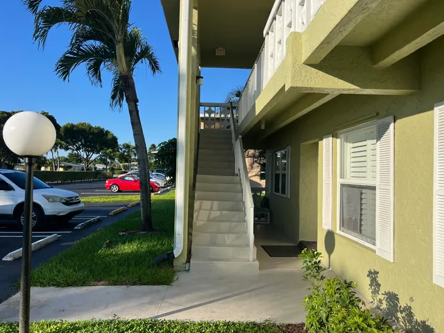 a view of a hallway with wooden floor and cabinet