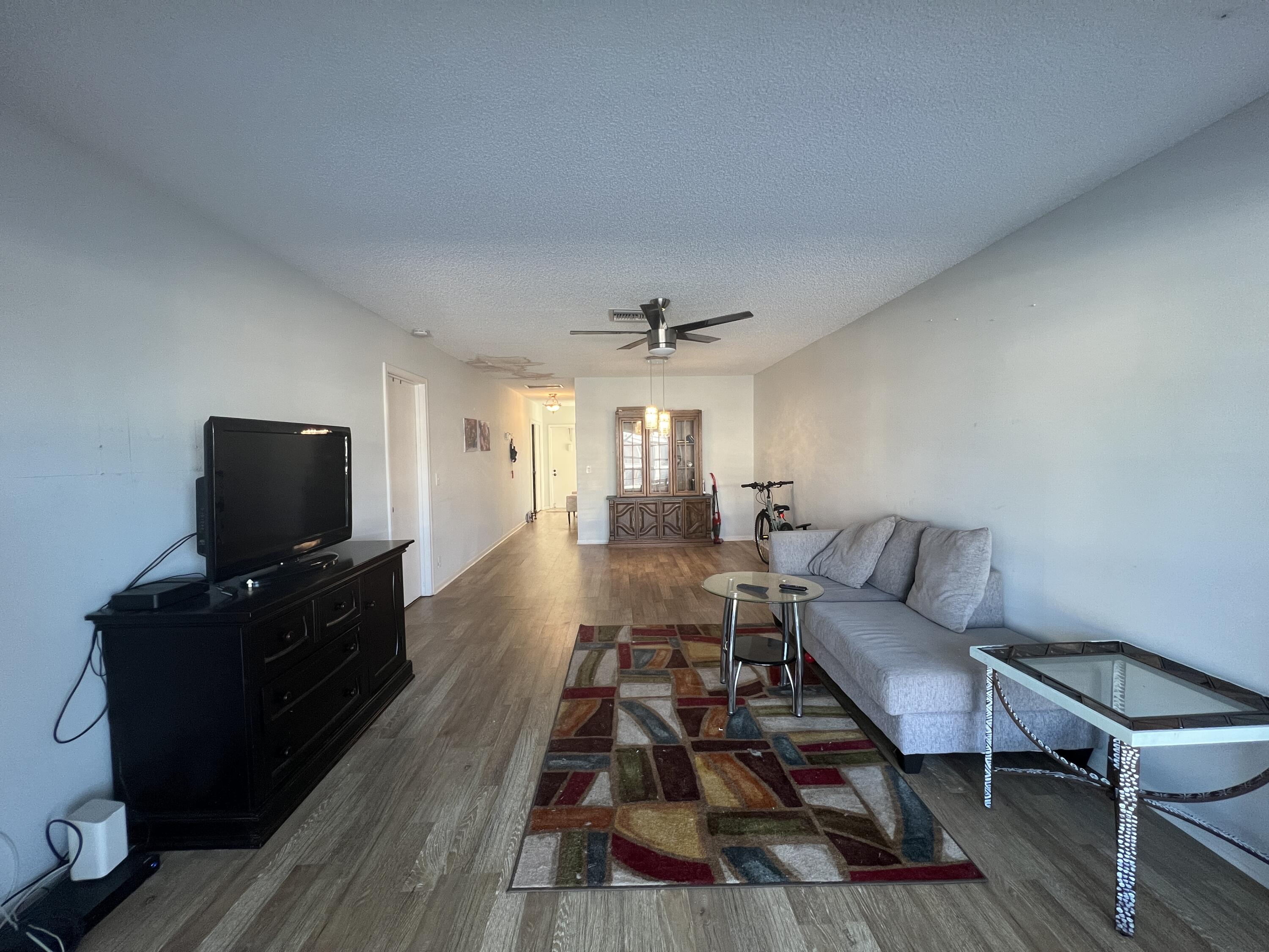 1150 Boxwood Drive, Unit 202 Delray Beach, FL 33445 - Photo 8 of 19 a living room with furniture and a flat screen tv