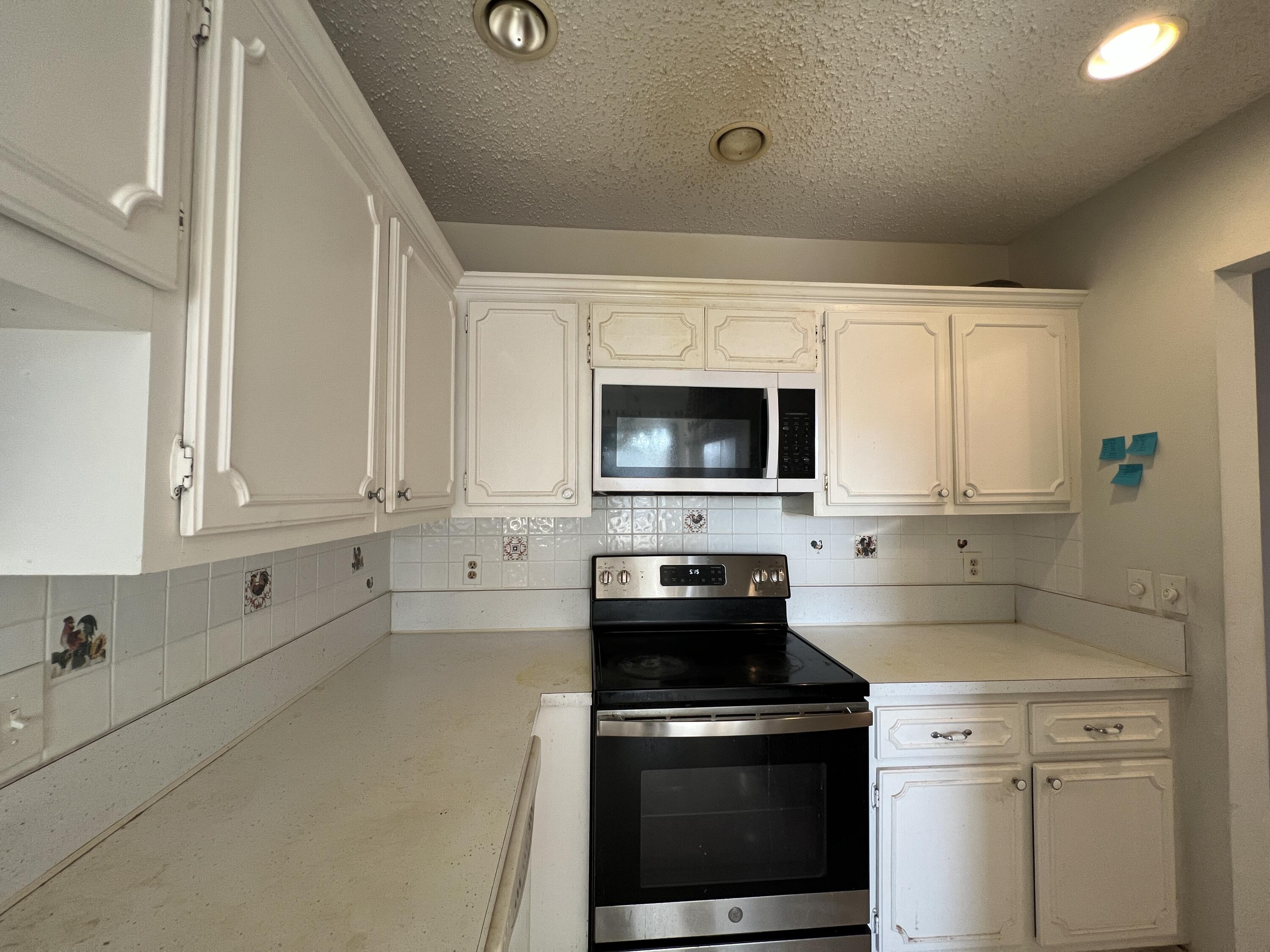 1150 Boxwood Drive, Unit 202 Delray Beach, FL 33445 - Photo 10 of 19 a kitchen with a stove and a white cabinets