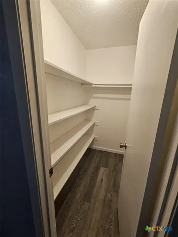 a view of walk in closet with empty racks