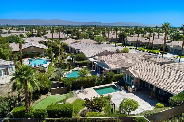 an aerial view of residential houses with outdoor space and ocean view