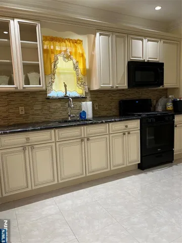 a kitchen with stainless steel appliances granite countertop a stove a sink and a microwave