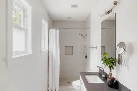 a bathroom with a sink a toilet and a shower