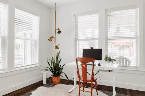 a view of a workspace with a window and furniture