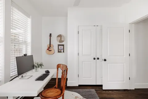 a bath room with a table chair and a window