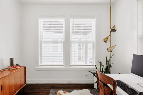 a bath room with a table chair and a window