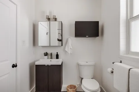 a bathroom with a toilet sink and mirror