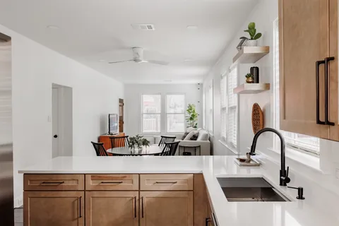 a kitchen with a white cabinets and chandelier