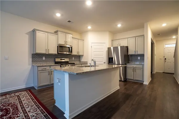 a kitchen with stainless steel appliances a refrigerator stove microwave and sink