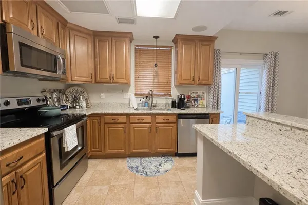 a kitchen with stainless steel appliances granite countertop a sink stove microwave and refrigerator