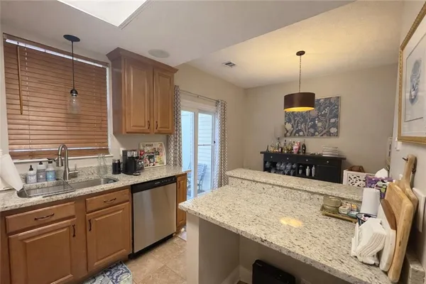 a kitchen with kitchen island granite countertop a sink a counter space appliances and cabinets