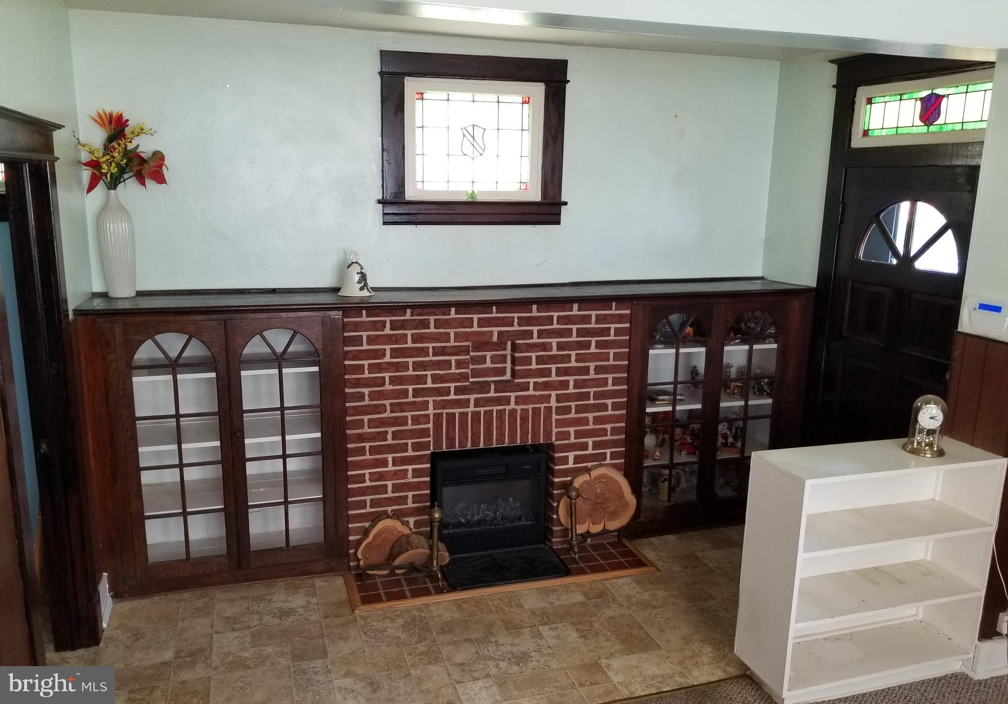 1115 Rosedale Avenue Baltimore, MD 21237 - Photo 11 of 27 a living room with furniture a fireplace and a flat screen tv