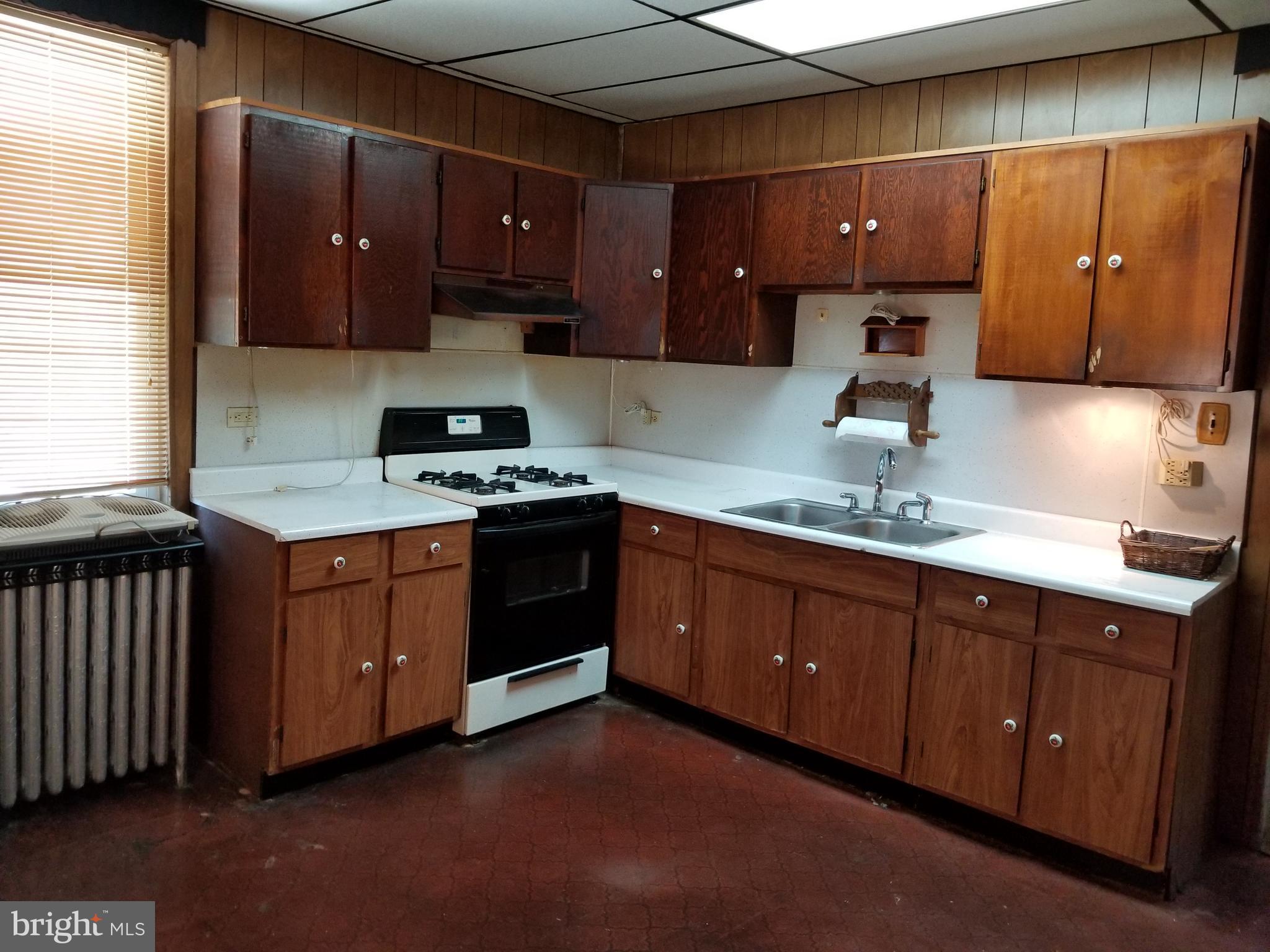 1115 Rosedale Avenue Baltimore, MD 21237 - Photo 14 of 27 a kitchen with stainless steel appliances granite countertop wooden cabinets a stove a sink and a window