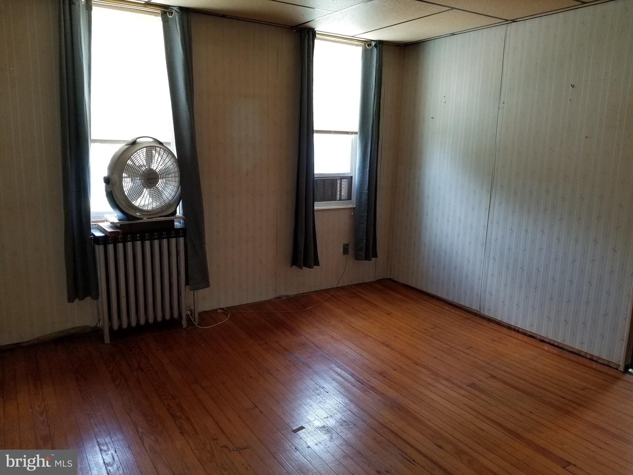1115 Rosedale Avenue Baltimore, MD 21237 - Photo 21 of 27 an empty room with wooden floor windows and entrance