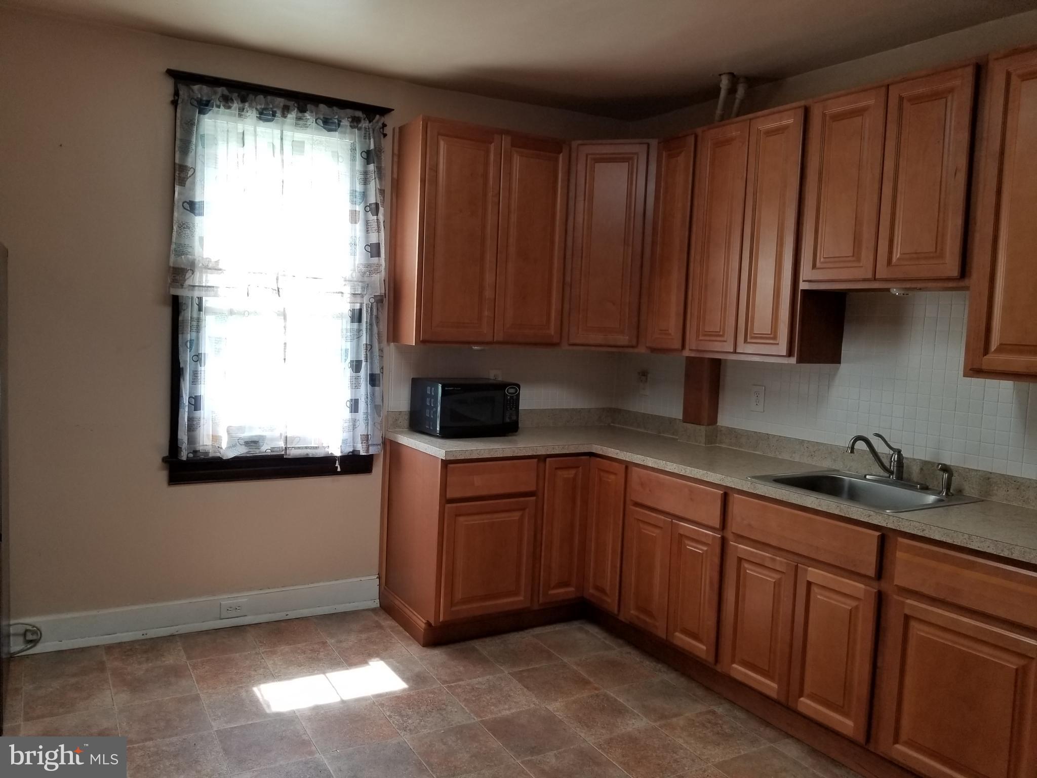 1115 Rosedale Avenue Baltimore, MD 21237 - Photo 5 of 27 a kitchen with stainless steel appliances granite countertop wooden cabinets a sink and a window