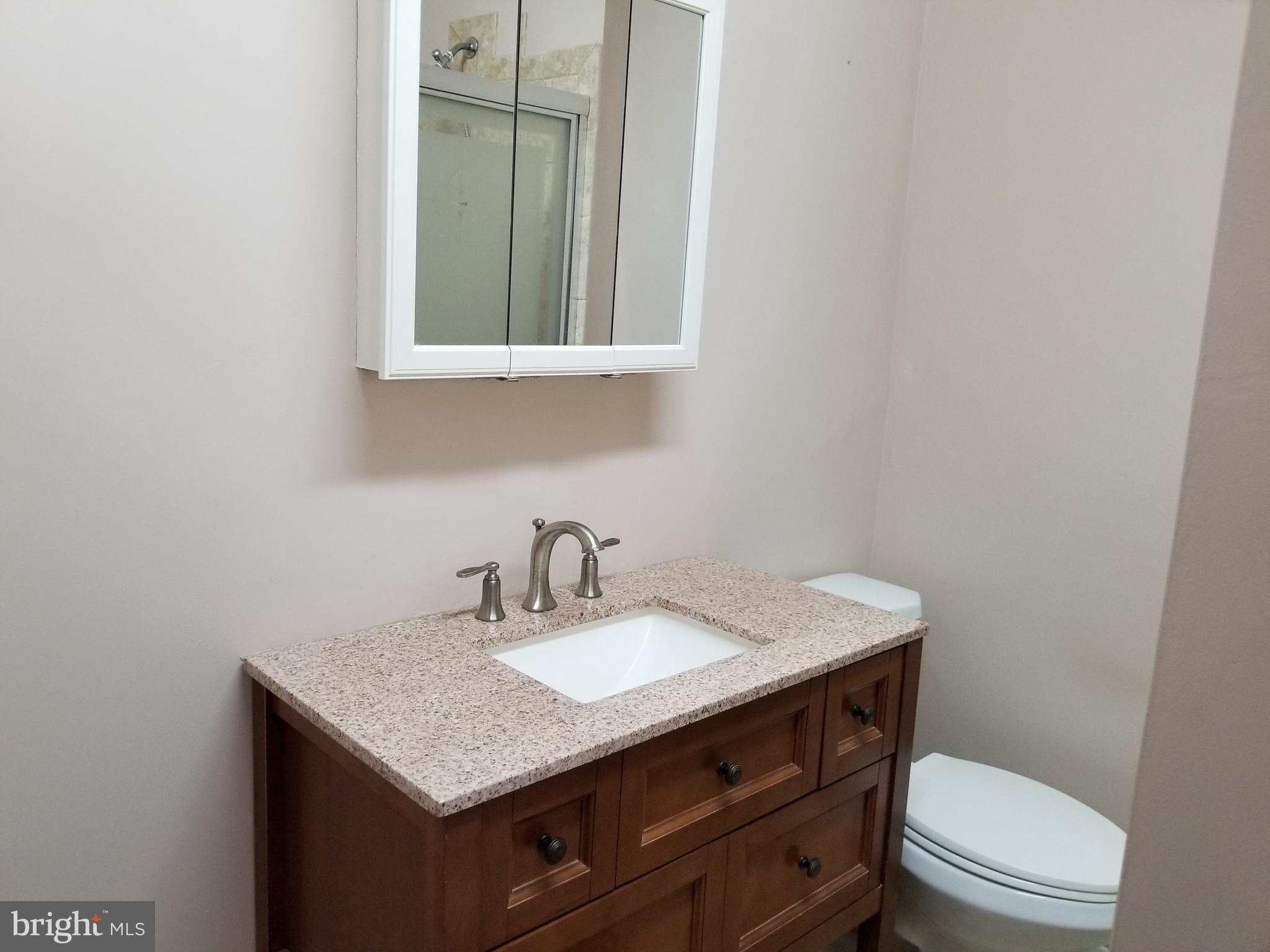 1115 Rosedale Avenue Baltimore, MD 21237 - Photo 8 of 27 a bathroom with a granite countertop sink toilet and mirror
