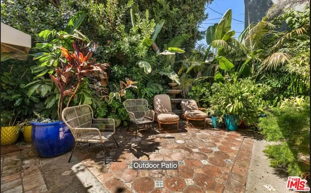 a view of a patio with table and chairs and potted plants
