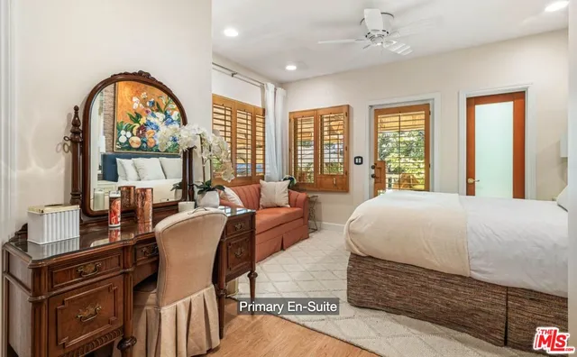 a spacious bedroom with a bed a dresser next to a large window