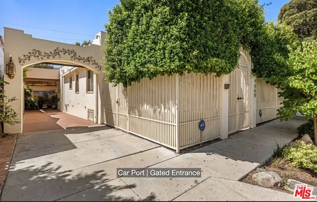 a front view of a house with white fence