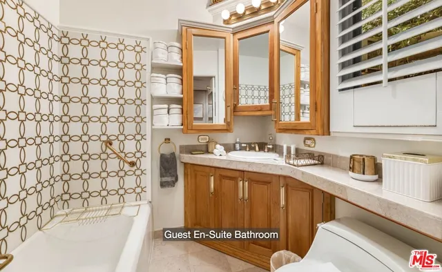 a bathroom with a granite countertop sink and a bathtub