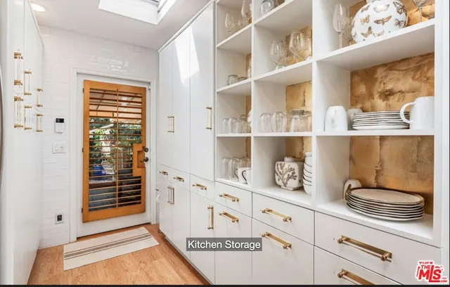 a kitchen with white cabinets and window