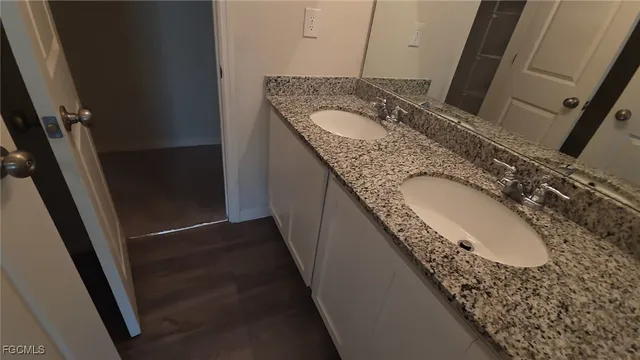 a bathroom with a granite countertop sink and a mirror