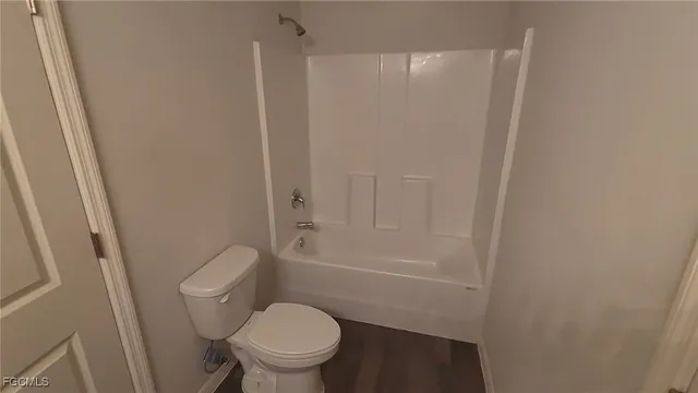 a bathroom with a granite countertop toilet a sink and a bathtub