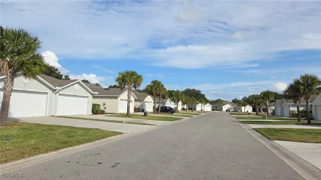 a view of a house with a big yard and palm trees