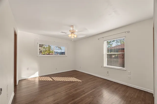 a view of room with wooden floor and ceiling fan