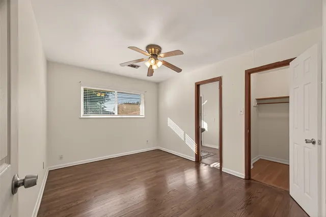 a view of a roof deck with table and chairs a barbeque with wooden floor and fence