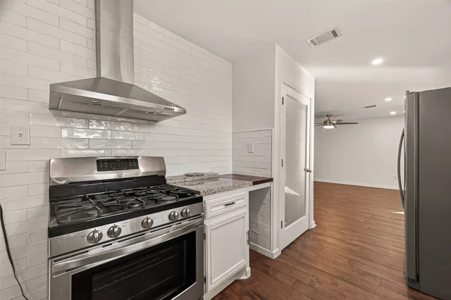 an empty room with wooden floor and ceiling fan
