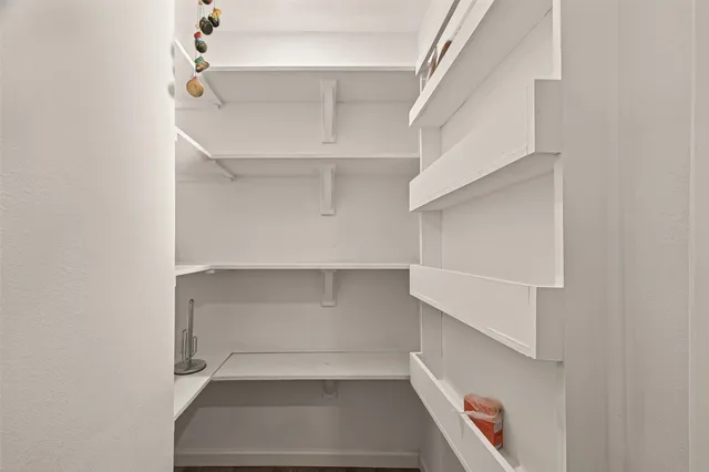 an empty room with wooden floor ceiling fan and windows