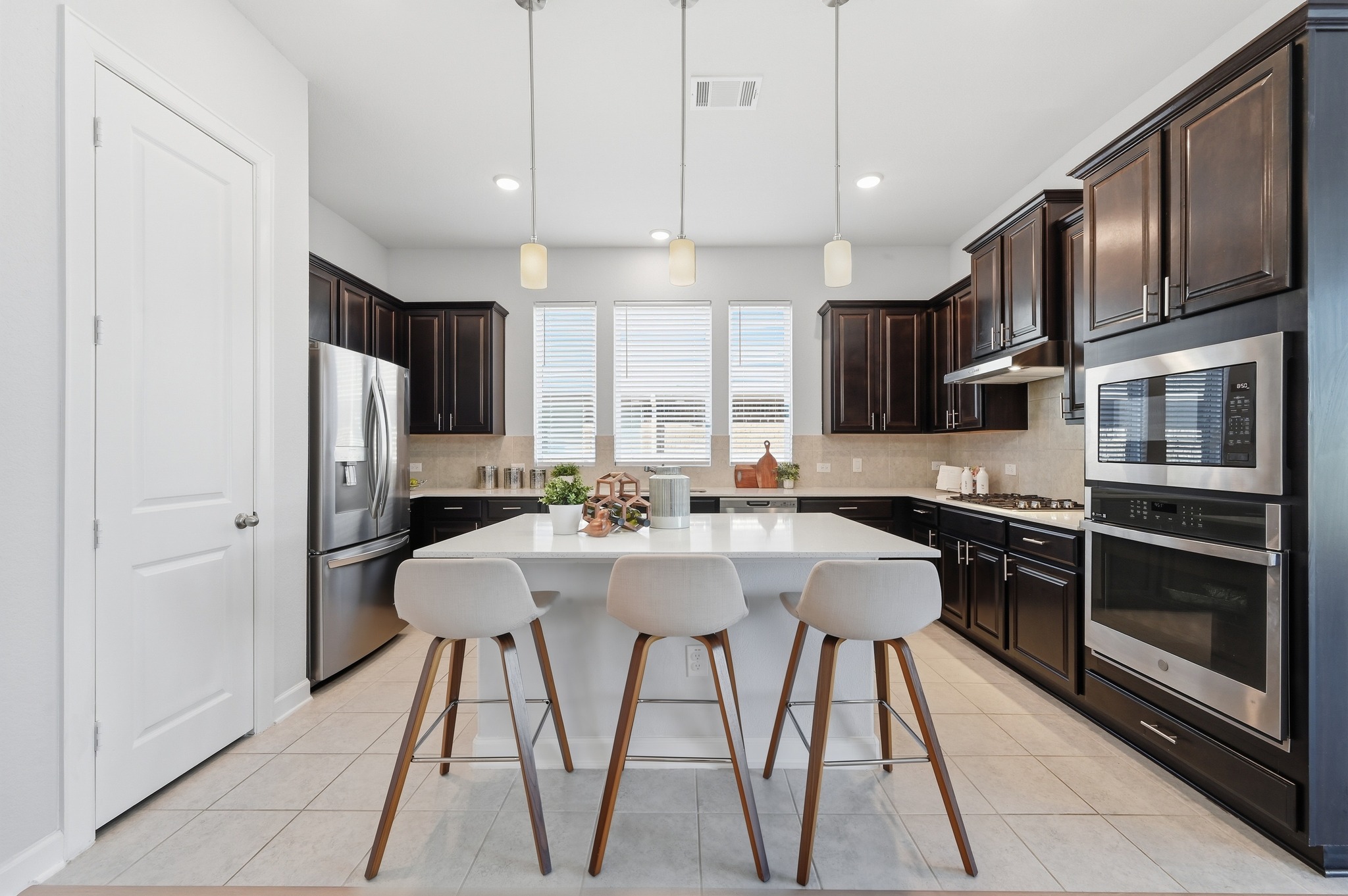 176 Wild Pecan Loop Buda, TX 78610 - Photo 12 of 30 Kitchen with a kitchen breakfast bar, stainless steel appliances, hanging light fixtures, and a center island