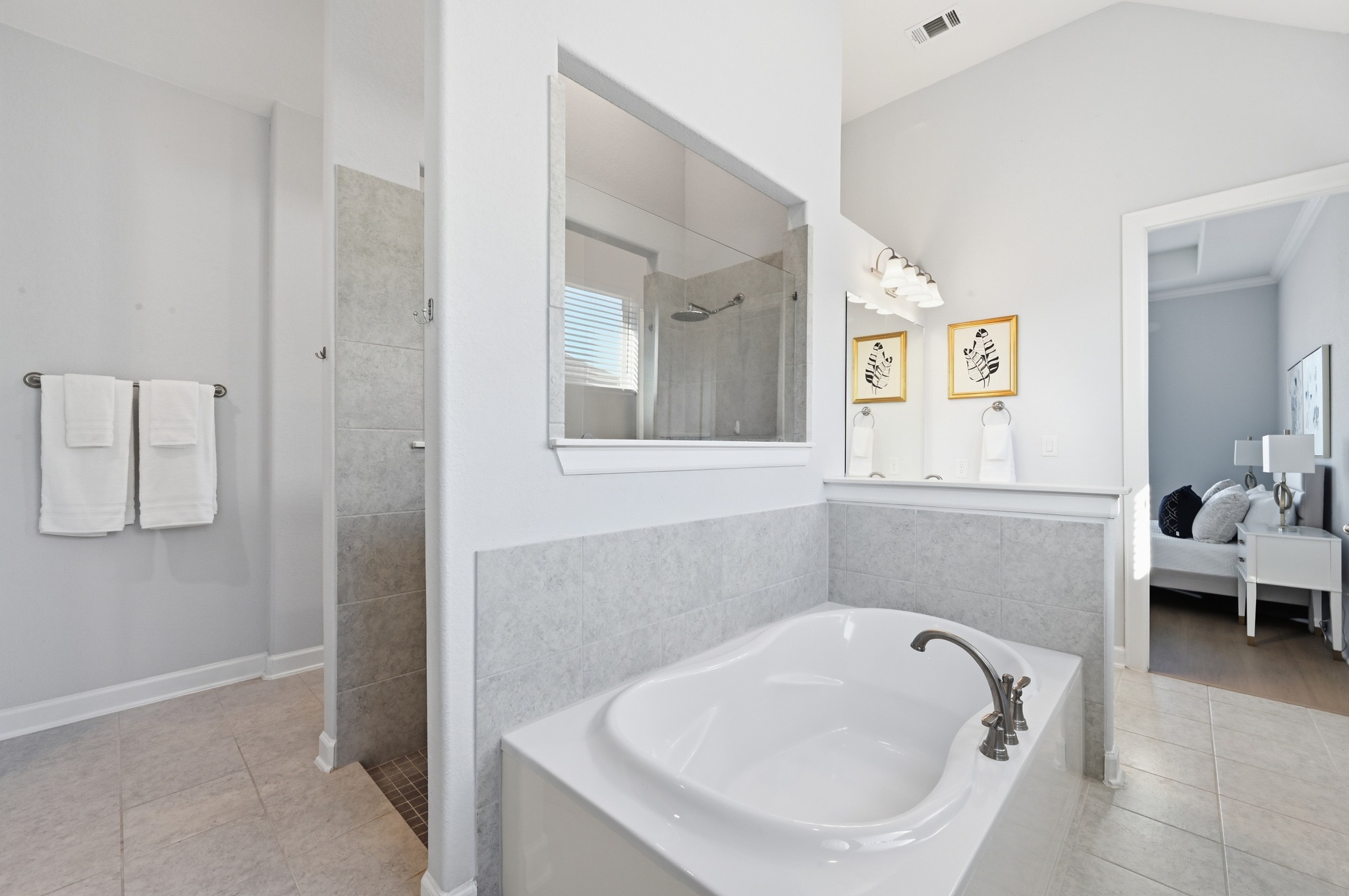 176 Wild Pecan Loop Buda, TX 78610 - Photo 14 of 30 Full bath featuring ensuite bathroom, a bath, light tile patterned floors, walk in shower, and vaulted ceiling