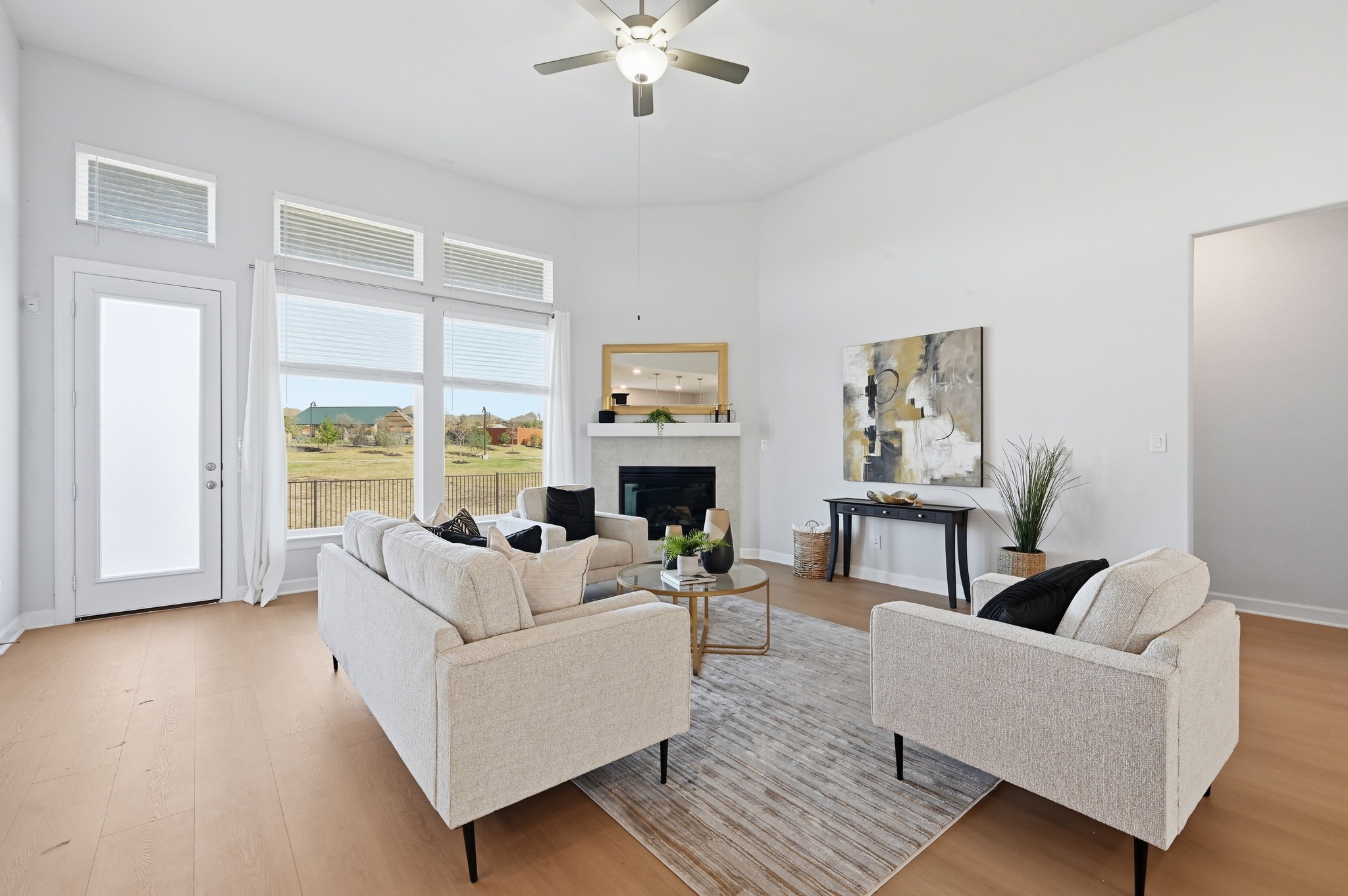 176 Wild Pecan Loop Buda, TX 78610 - Photo 4 of 30 Living room with a high ceiling, light wood-style flooring, a ceiling fan, and a fireplace