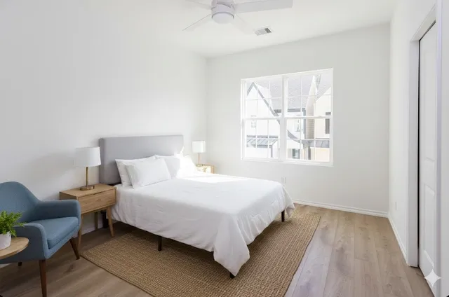 a large bed sitting in a bedroom next to a window