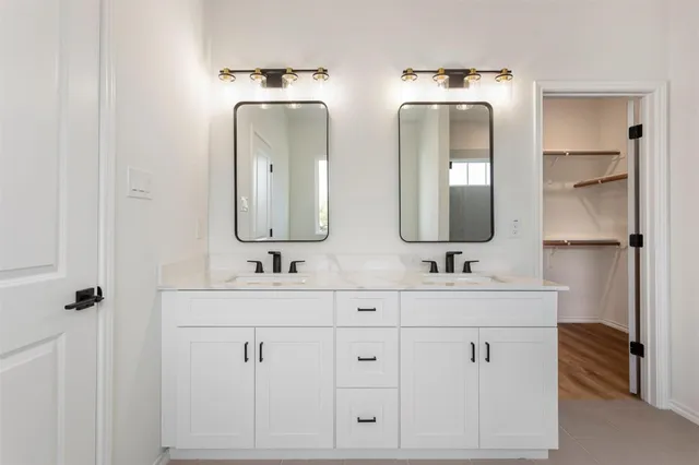 a bathroom with double vanity sinks and a mirror